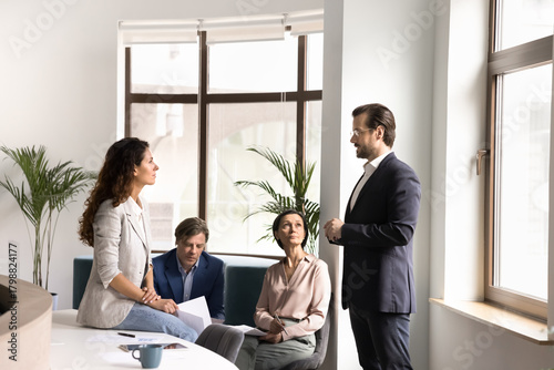 Engaged multiethnic workers gather in office hall for casual conversation