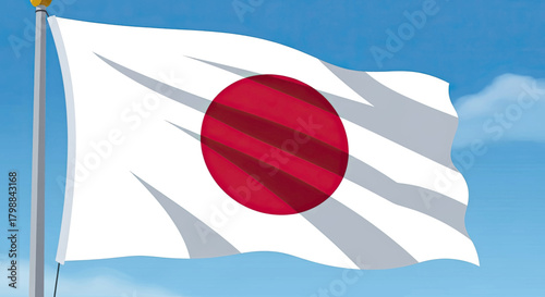 The national flag of Japan, known as the Nisshōki or Hinomaru, waving in the wind against a blue sky.