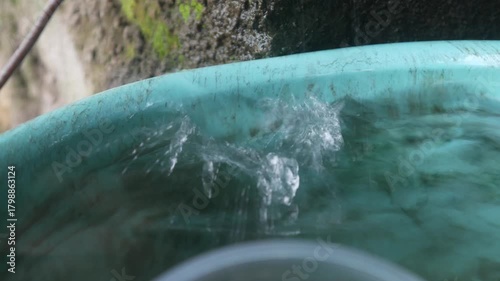 water droplets fall into a bucket filled with water