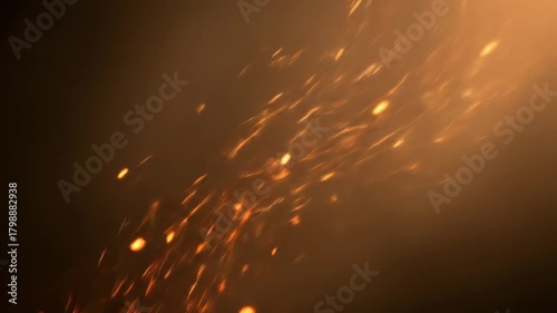 Abstract orange sparks fly upwards against dark background usable for motion graphics.
