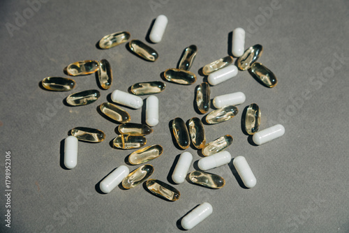 Transparent fish oil capsules alongside white iron capsules