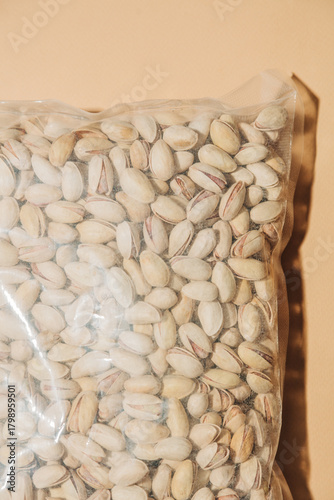 Salted pistachios in plastic bag green background