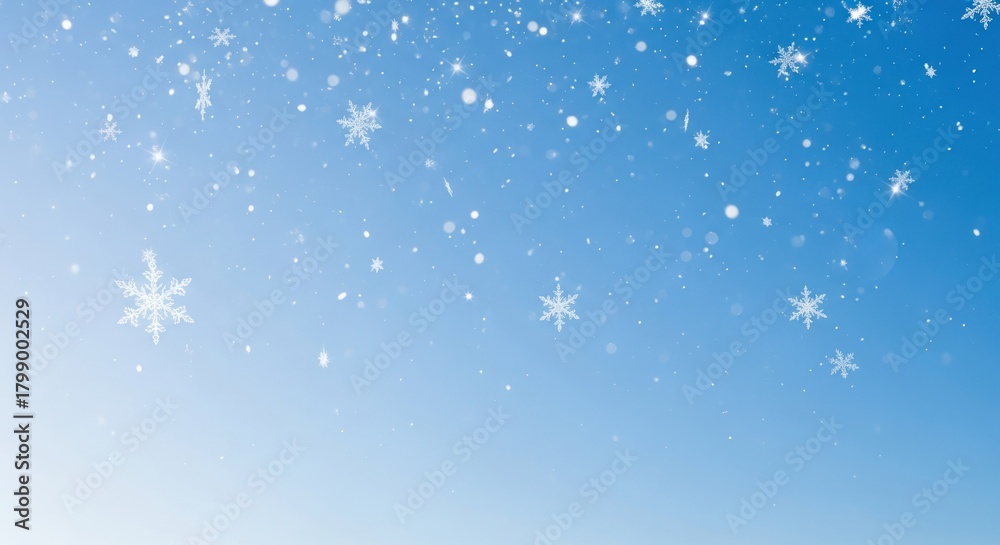 Fototapeta premium Snowflakes falling against a blue sky.