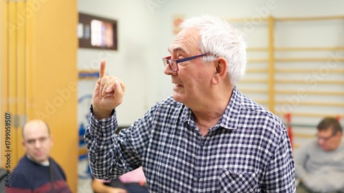 Senior man using sign language, promoting inclusive language