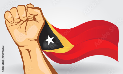 National flag of Timor Leste is flying with a clenched fist, the flag is red, orange and black.