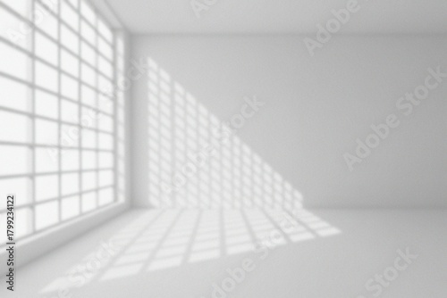 A minimalist interior with sunlight casting shadows from a large window