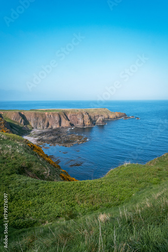 Scenic green coastal cliffs and rocky bay