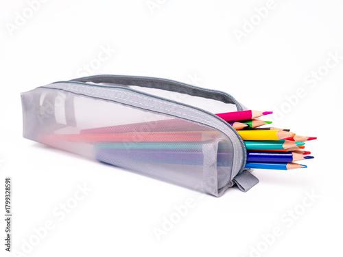 Colored pencils in a gray pencil case on a white background