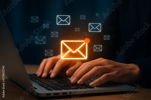 A person's hands are typing on a laptop with a bright glowing new email notification icon surrounded by many smaller floating envelope symbols representing communication or messages