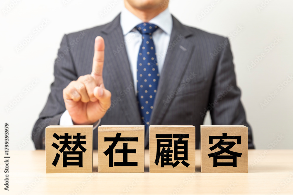 Obraz premium 「潜在顧客」と書かれたブロックとビジネスマン