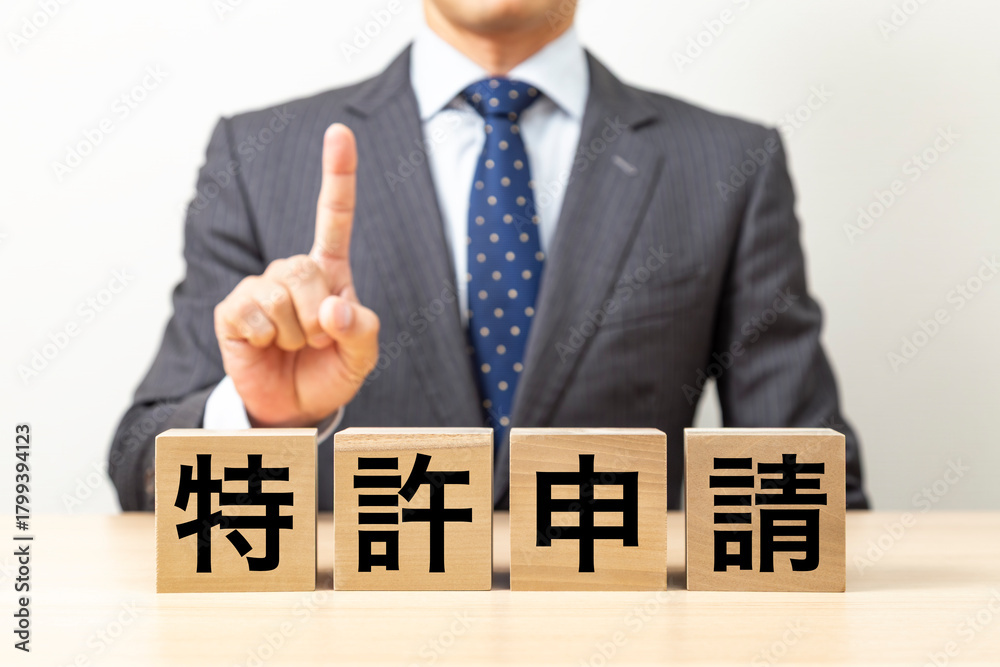 Obraz premium 「特許申請」と書かれたブロックとビジネスマン