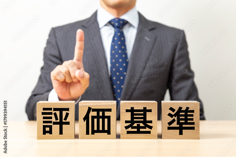 Obraz premium 「評価基準」と書かれたブロックとビジネスマン