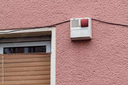 Building facade with security alarm system and roller shutter