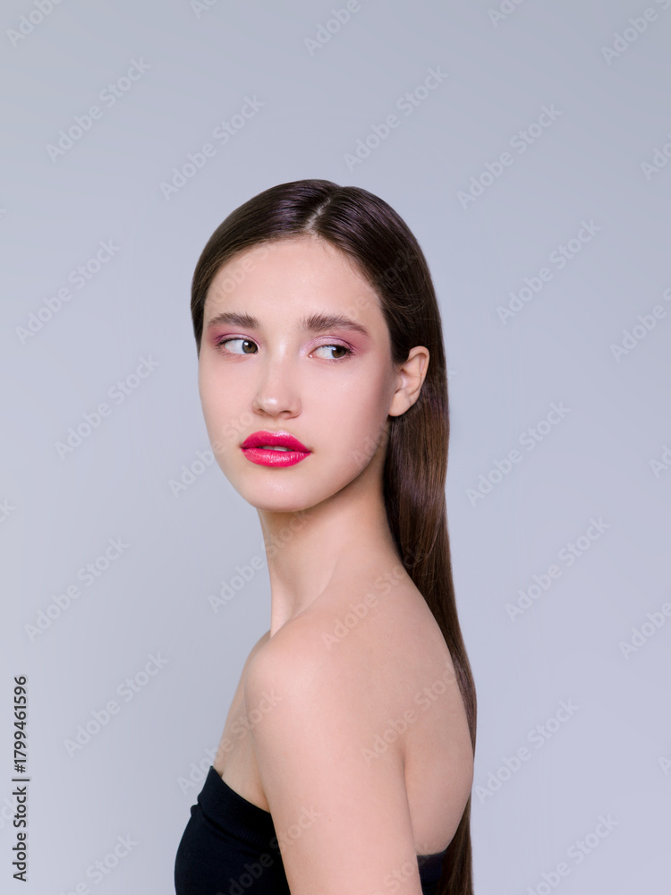 Naklejka premium Beautiful brunette young woman with glowing make-up on blue background Fashion model close-up beauty shot stock photo
