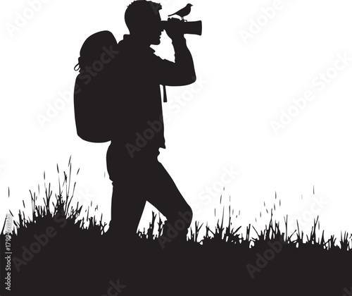 Black silhouette of man with backpack and camera with bird on lens