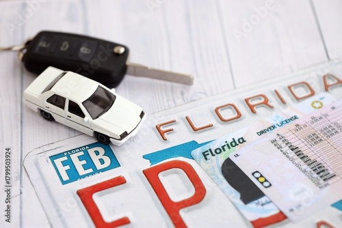 Remote control car keys on Florida license plate with driver license. Concept of driving in Florida. Reaching a driving permit