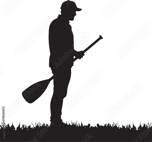 Silhouette of man in baseball cap holding paddle on grass
