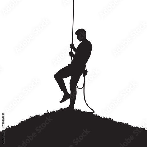 Silhouette of man rappelling down a grassy hill climbing