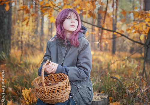 Young girl holding mushroom basket in autumn forest