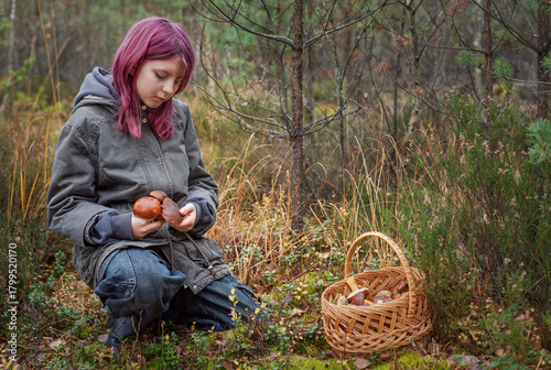 Young girl mushroom picking in autumn forest