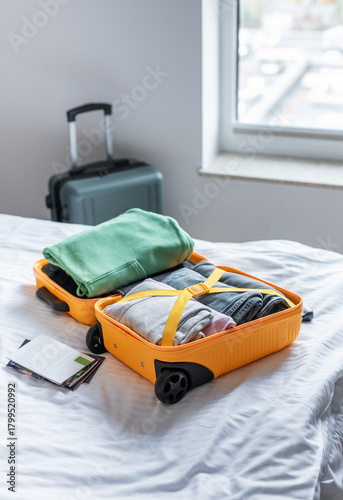 Open suitcase filled with clothes packing for travel