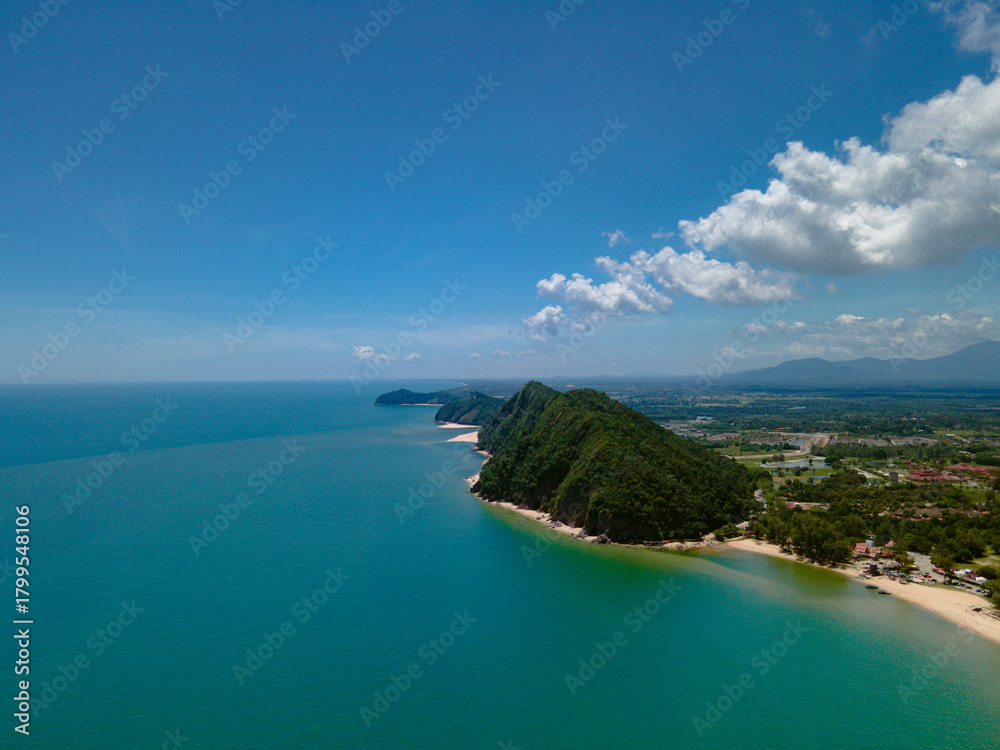 Fototapeta premium Aerial view of Pantai Bukit Keluang, Besut, Terengganu, showing turquoise waters, coastal cliffs, and clear sunny skies along the scenic shoreline.