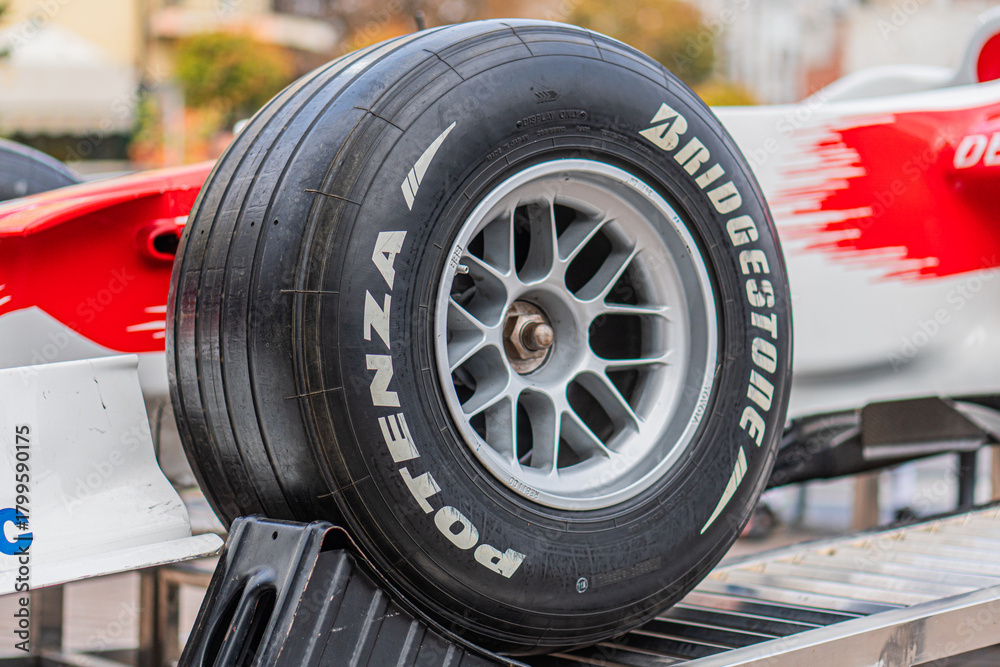 Naklejka premium White and red Toyota Formula 1 car TF-108 on a metal grid stand, parked in a garage or pit area Car has visible front and rear wings, tread pattern detail on one ti - Kyiv, Ukraine 10-10-2024