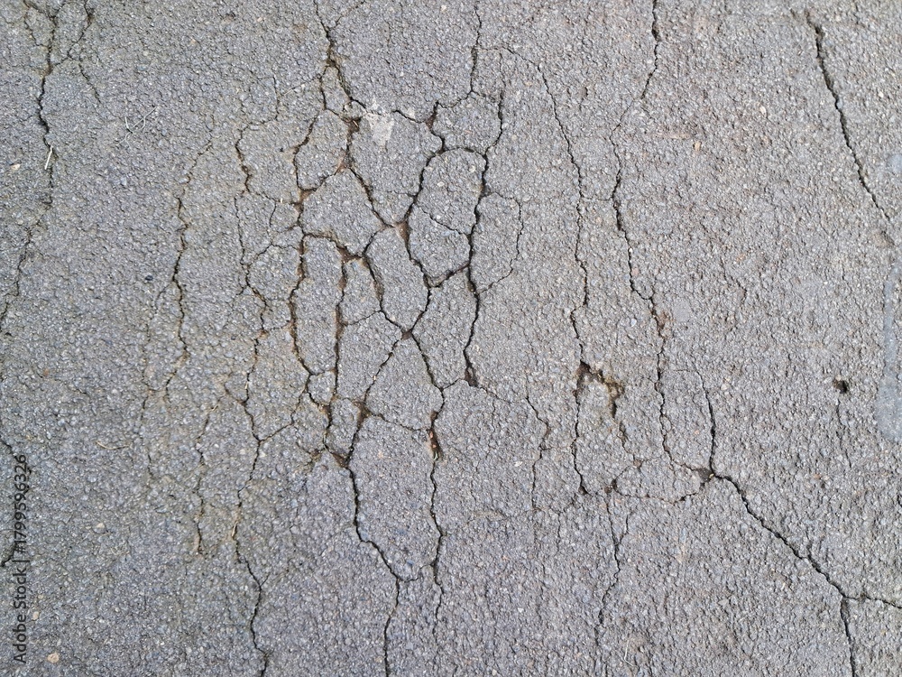 Obraz premium Cracked and damaged asphalt texture, highway damage. Emergency conditions on asphalt. For background or industrial use.