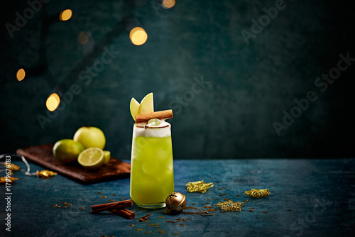 Festive Green Holiday Cocktail with Apple and Cinnamon Garnish