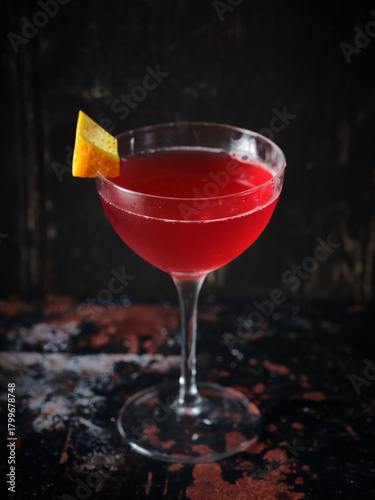 Vibrant Red Cocktail with Orange Twist Garnish in Coupe Glass