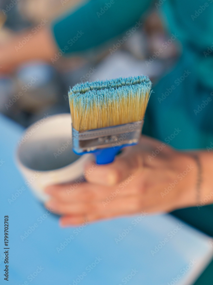 Naklejka premium Artist Holding Brush with Blue Paint