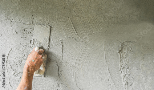 Plaster cement wall background, Hand worker holding handle trowel plastering polish grey mix mortar concrete fresh texture, Equipment people job construction house site masonry structure