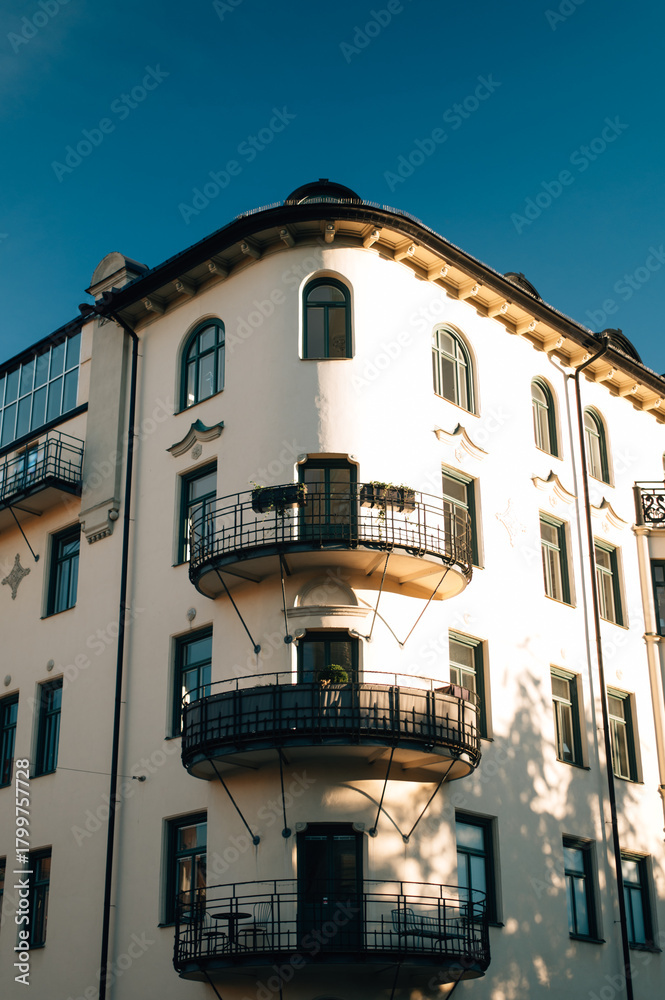Obraz premium Elegant white building with decorative balconies and wooden window frames