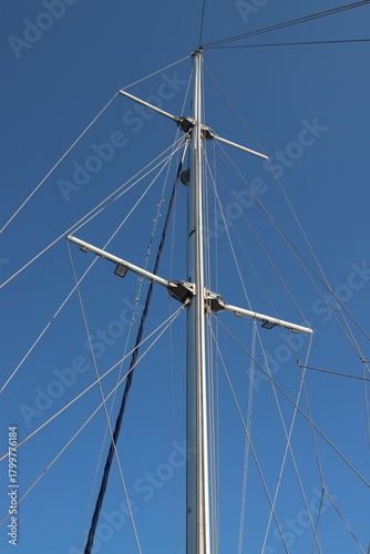 Sailboat mast and rigging against a clear blue sky