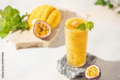Mango passionfruit smoothie or cocktail  in drinking glass on the table. Hard light