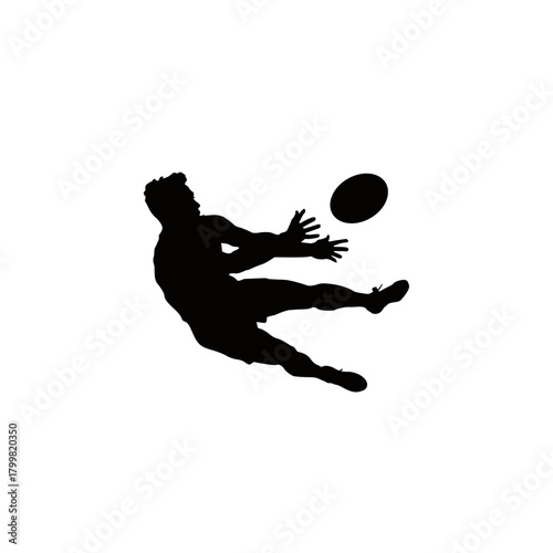 Silhouette of a rugby player kicking the ball in mid air during a dynamic game action