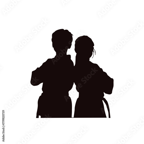 Two young children silhouetted in martial arts uniforms practicing together in a studio