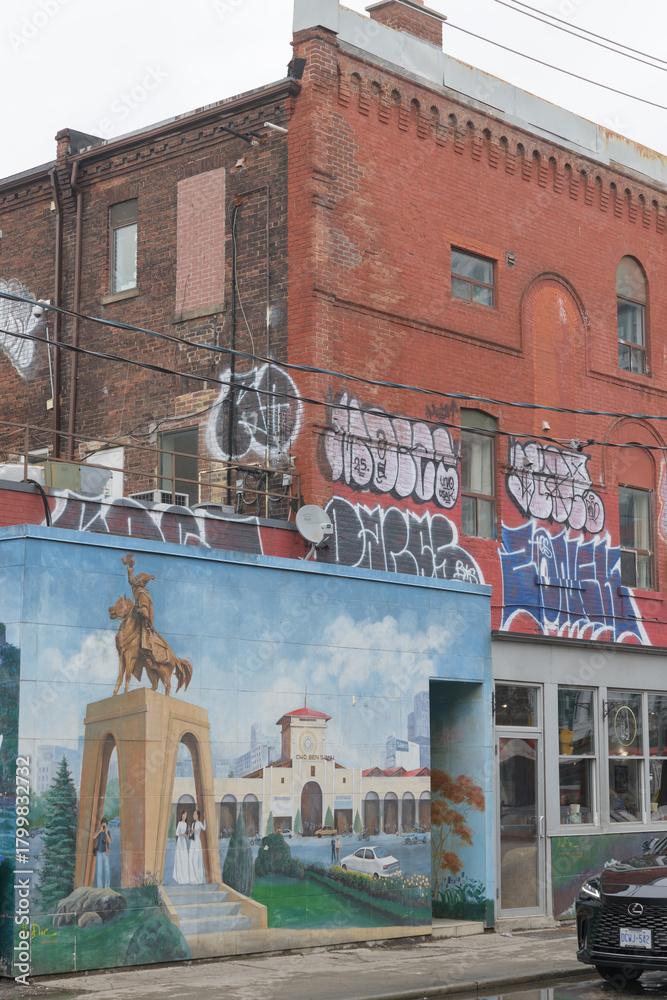 Fototapeta premium wall mural outside Original Ka Chi (Kensington market) at 8 St Andrew St and historic building at 350 Spadina Av, Toronto