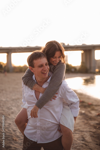 Romantic Couple Embracing at Sunset on a Beach with Soft Warm Light and Blurred Background