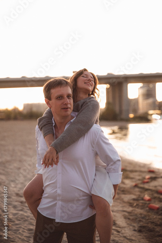 Romantic Couple Embracing at Sunset on a Beach with Soft Warm Light and Blurred Background
