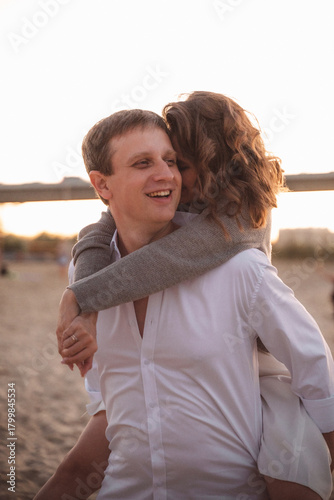 Romantic Couple Embracing at Sunset on a Beach with Soft Warm Light and Blurred Background