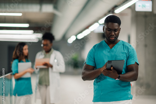 Healthcare professional using tablet and team working in hospital