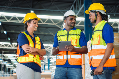 Diverse workfoce team black men,woman factory worker wear safety helmet, safety vest use tablet for industrial warehouse job.Teamwork efficient success modern logistic manufacture operation management