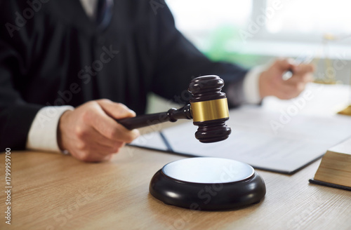 Konstfotografi Man judge knocking gavel wearing robe having court verdict sitting at the desk on workplace in courtroom