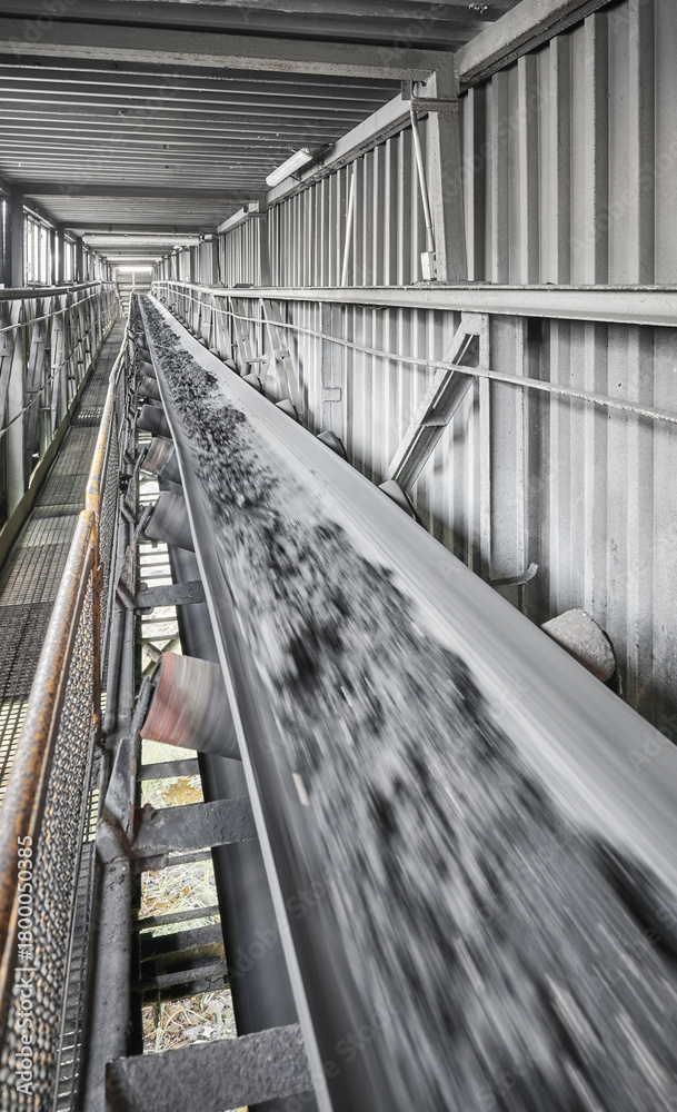 Fototapeta premium Belt conveyor transporting coal in a heating plant, selective focus.