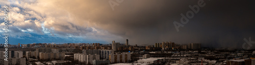Fotografie Moscow, Russia - October 15, 2025: Panorama of a big city from a height a snowstorm is approaching the blue sky