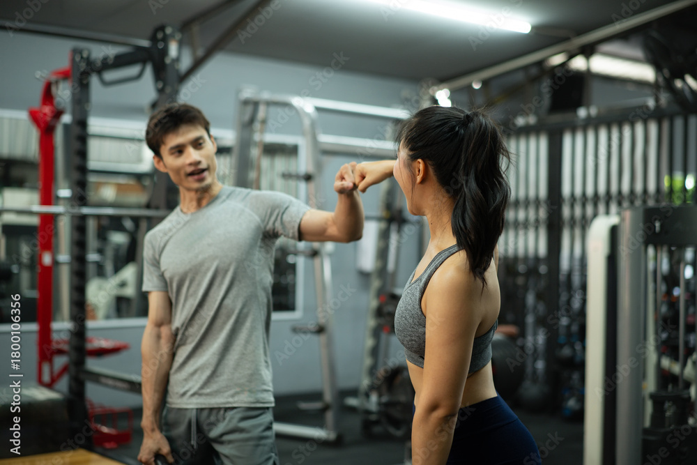 Obraz premium A trainer and woman greeting with a fist bump in the gym