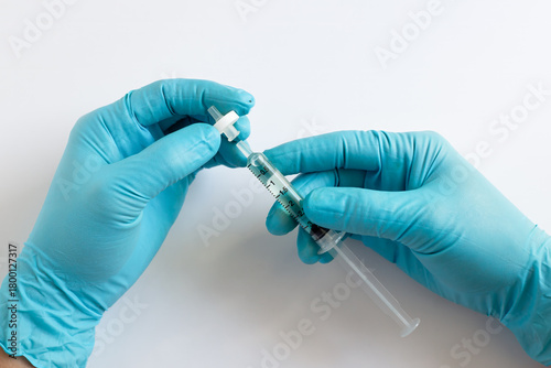 Fototapeta A scientist in blue gloves prepares a sample by attaching a syringe filter to a syringe for sample preparation before injecting it into the HPLC in laboratory