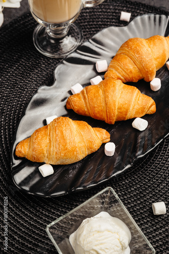 An airy golden croissant on a dark background for breakfast whets the appetite