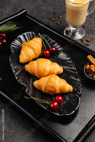 An airy golden croissant on a dark background for breakfast whets the appetite